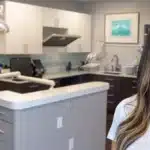 a smiling patient showing off their new affordable dental implants in a bright, modern dental office.