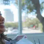 a smiling patient receiving affordable dental implants with the tyler, texas skyline in the background.