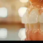 a close-up shot of a perfect, luminous smile with flawless composite veneers, set against a blurred background of a dental office in tyler.