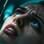 a close-up of a wincing patient with tears in their eyes during a tooth extraction, highlighting the intense pain.