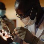 a compassionate dentist providing free emergency dental care to a grateful low-income patient.