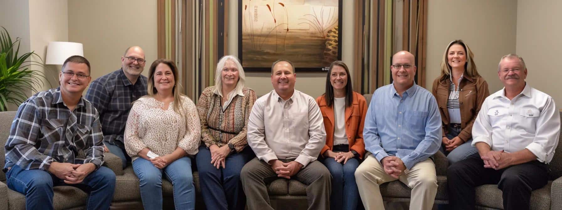 a group of smiling patients in crowley, tx sit comfortably in a cozy dental office, sharing their positive experiences and successful root canal pain management stories.