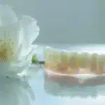 a close-up photo of a sturdy dental implant supporting a denture, showcasing the seamless integration between the two components for a natural and restored smile.