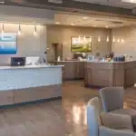 a smiling patient receiving a root canal treatment in a modern dental office in tyler, texas, with a visible payment plan brochure on the counter.