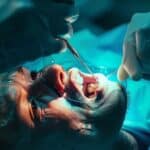 a dentist carefully extracting a tooth with precision and focus, using delicate instruments.