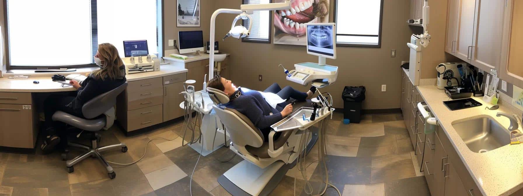 a smiling patient reclining comfortably in a dental chair as a dentist skillfully performs a root canal, surrounded by modern equipment and a soothing atmosphere.