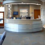 a bright, inviting dental clinic displays a radiant, life-sized dental implant model alongside a gleaming smile, highlighting the transformative oral health benefits of implants in a warm, natural light setting.