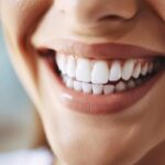 a bright, inviting dental clinic features a confident patient smiling with pristine dental implants, reflecting a sense of comfort and successful recovery in a modern, well-lit environment.