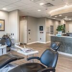 a bright, modern dental office featuring a knowledgeable dentist engaging a patient in a thoughtful discussion about dental implants, with sleek instruments and a calming ambiance in the background.