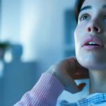 a close-up of a concerned patient examining an x-ray that highlights the signs of dental implant failure, illuminated by soft, clinical lighting in a modern dental office.