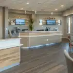 a warm, inviting dental clinic interior showcases a diverse group of smiling patients discussing accessible dental implants payment plans, highlighting the ease and comfort of affordable dental care.