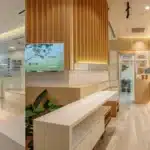a pristine dental clinic with a bright, inviting atmosphere features a close-up of a gleaming dental implant next to natural teeth, highlighting the contrast between modern dental solutions and traditional alternatives.