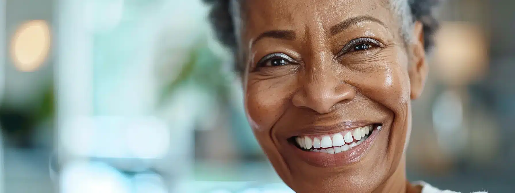 a radiant smile showcases a seamless set of dentures, highlighting their immediate aesthetic appeal and confidence-boosting benefits against a softly lit, inviting background.