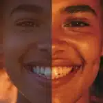 a striking split-image showcasing a radiant smile with lifelike dental implants on one side and a contrasting, less natural smile with dentures on the other, illuminated by soft, diffused lighting to highlight the aesthetic differences.