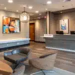 a modern dental clinic in dallas, texas, showcases a sleek reception area with vibrant artwork, inviting patients into a serene space geared towards providing affordable root canal treatments.