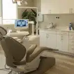 a close-up view of a dental consultation room, highlighting a concerned patient seated in an ergonomic chair, with a dental professional in a white coat examining a digital x-ray on a screen, capturing the concern and expertise surrounding dental implant aftercare.