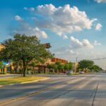 a vibrant urban street view in tyler, texas, featuring a modern office building with a large, inviting sign advertising affordable payment plans, under bright, clear skies for an engaging atmosphere.