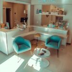 a welcoming dental clinic in lake worth, texas, featuring a modern, bright consultation area with comfortable seating, where a friendly dental professional discusses affordable dentures and implants with an engaged patient.