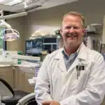 a smiling dentist in a modern office, offering affordable care with flexible payment options in tyler, tx.