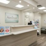 a bright and modern dental clinic in mansfield, texas, showcasing a welcoming reception area with informative brochures about dentures prominently displayed.