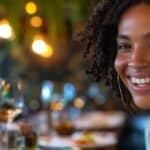 a confident individual smiles brightly while enjoying a delectable meal at a stylish, modern restaurant, showcasing the seamless integration of dental implants in their lifestyle.