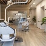 a modern dental clinic showcases a confident patient smiling widely after a successful dental implant procedure, with sleek, high-tech equipment and a bright, welcoming atmosphere enhancing the sense of satisfaction and care.