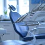 a modern dental clinic showcases a confident patient smiling brightly after receiving all-on-4 dental implants, with sleek dental equipment and soothing colors creating a professional and inviting atmosphere.