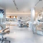 a polished dental clinic showcases a sleek, modern treatment room with advanced dental implant equipment and a detailed anatomical model of a jaw, emphasizing the benefits of dental implants in a clean, professional setting.