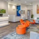 a modern dental clinic in lake worth, texas, featuring a sleek reception area with bright, inviting colors and advanced dental equipment prominently displayed, conveying a sense of professionalism and accessibility for affordable dentures and implants.