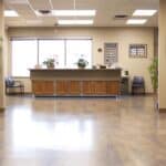 a bright and welcoming dental clinic reception area in mansfield, texas, featuring a modern design with comfortable seating and informative brochures on affordable denture options displayed prominently.