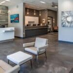 a modern dental clinic in granbury, texas, showcasing a sleek reception area with welcoming staff and high-tech dental equipment, emphasizing affordable dentures and implants in a bright, professional setting.