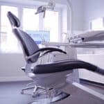 a modern dental clinic interior, featuring a sleek, high-tech dental chair surrounded by advanced imaging equipment, illuminated by soft, focused lighting, conveying a sense of precision and care in the realm of dental implant success.