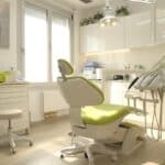 a modern dental clinic features a bright, welcoming treatment room with a comfortable dental chair and high-tech equipment, illustrating a focused discussion between a dentist and a child about dental implants.