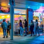 a vibrant urban storefront in tyler, texas, showcasing a welcoming sign advertising affordable payment plans, with engaging customers eagerly entering the well-lit interior.