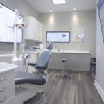 a modern dental clinic in lake worth, featuring a sleek interior with advanced implant technology on display, highlighting a vibrant comparison chart on a digital screen showcasing success rates.