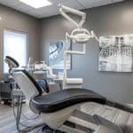 a modern dental clinic in denton, showcasing a sleek, high-tech treatment room where a patient is receiving a dental implant procedure under bright, clinical lighting.