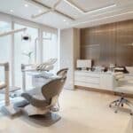 a modern dental clinic interior featuring a sleek consultation area with polished surfaces and dental equipment, emphasizing the professionalism and advanced technology associated with dental implant replacements.