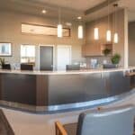 a modern dental office in tyler, texas, featuring a sleek reception area with a welcoming atmosphere, showcasing brochures on affordable dentures and implants alongside contemporary dental equipment.