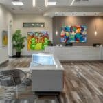 a modern dental office in cleburne, texas, featuring a sleek reception area with vibrant artwork and comfortable seating, emphasizing a welcoming environment for patients seeking affordable dentures and implants.