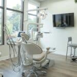 a modern dental office interior features a welcoming consultation area with sleek, high-tech dental equipment and a knowledgeable dentist engaging with a patient, highlighting the importance of early detection and intervention for maintaining dental implants.