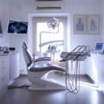 an illuminated dental clinic office features a sleek, modern dental chair surrounded by sophisticated equipment, emphasizing the stark contrasts of high-tech solutions and the hidden expenses of dental implants.