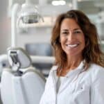 a confident individual in a bright, modern dental office smiles broadly, showcasing their pristine dental implants while surrounded by advanced dental technology and comforting design elements.