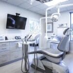 a modern dental clinic in lake worth features a sleek, high-tech treatment room with advanced dental equipment and a confident patient seated comfortably in an ergonomic dental chair, conveying a sense of professionalism and innovation in dental implant revision procedures.