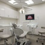 a modern dental clinic in lake worth features a state-of-the-art treatment room with sleek equipment, illuminated by soft overhead lighting, showcasing a patient comfortably seated in a high-backed chair, illustrating the advanced technology behind dental implants.