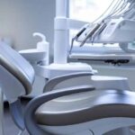 a modern dental clinic showcases a sleek examination room, featuring a state-of-the-art dental chair and a detailed anatomical model of dental implants, highlighting advanced tooth replacement solutions in a bright, sterile environment.