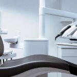 a modern dental office, featuring a sleek dental chair and high-tech equipment, showcases a dentist meticulously adjusting a custom-made porcelain crown that perfectly matches the color and translucency of natural teeth, symbolizing the advanced technology and artistry behind undetectable dental implants.