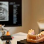a modern dental office in mansfield, tx, showcasing a confident patient smiling with a set of lifelike dentures on display, surrounded by advanced dental technology and a knowledgeable prosthodontist engaging in a consultation.
