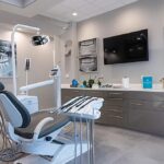 a sleek dental clinic interior, featuring a modern consultation room with a pristine dental chair, advanced imaging technology, and a vibrant display of dental implant models, embodying the innovative and restorative essence of dental implants for patients in lake worth.