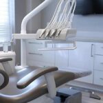 a sleek dental office in lake worth, featuring a modern treatment area with a high-tech dental chair and pristine instruments, where a dentist is explaining the benefits of dental implants to a patient, emphasizing the transformation and confidence these implants can bring.