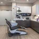 a modern dental clinic interior, showcasing a sleek, high-tech consultation area with advanced dental equipment and a digital treatment plan displayed on a screen, emphasizing a professional and caring environment for patients considering dental implants.
